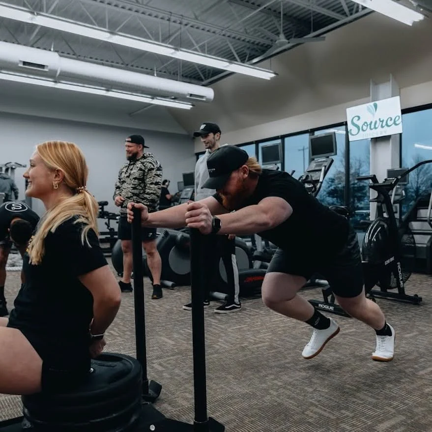 Members pushing a sled together at E’ville Fitness