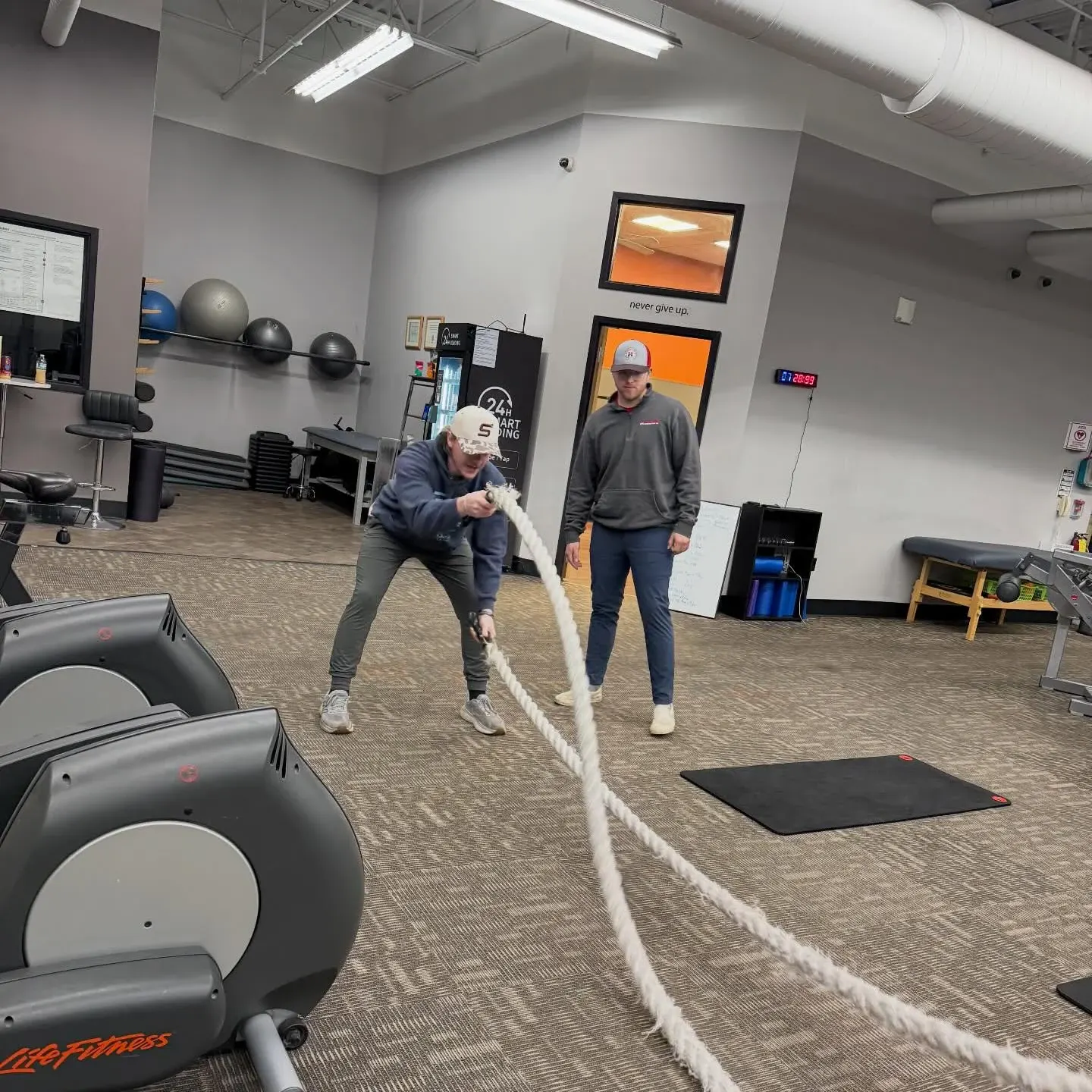 Member and coach on battle ropes at E’ville Fitness